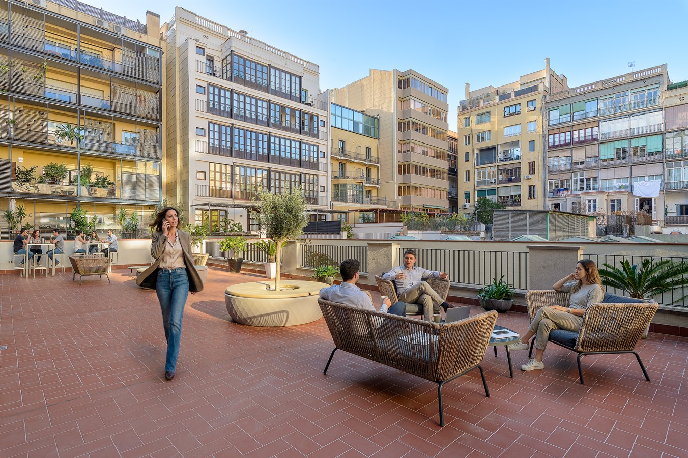 Terraza exterior con sillones y personas trabajando
