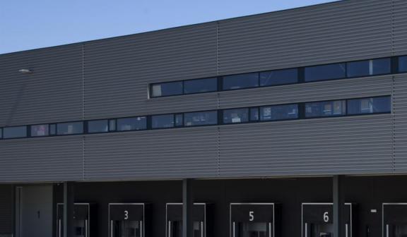 Fachada industrial genérica gris sobre cielo azul