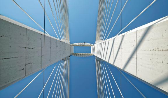 Imagen de puente visto desde abajo. Cielo azul